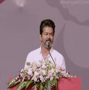 a man stands at a podium with flowers in front of him and the hashtag sanga230