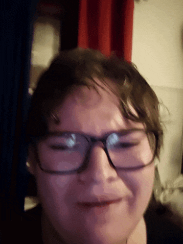 a close up of a person wearing glasses and making a face