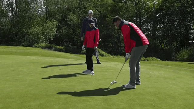 a man in a red jacket is putting on a green