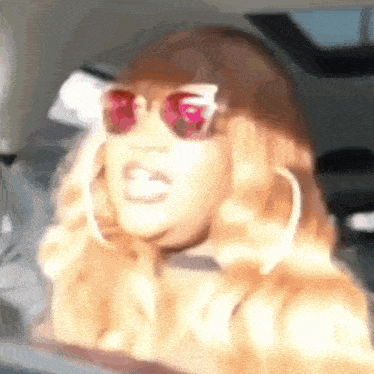 a close up of a woman wearing sunglasses and earrings .