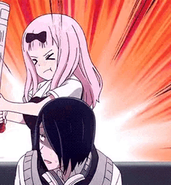 a girl with pink hair is holding a bat over a boy 's head .
