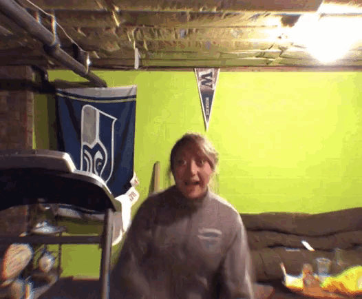 a woman standing in front of a seahawks banner