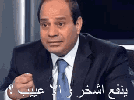 a man in a suit and tie with arabic writing on the bottom