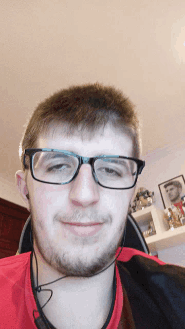 a man wearing glasses and ear buds is smiling
