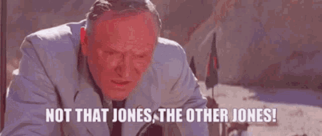 a man in a suit is holding a baby and says `` not that jones , the other jones '' .