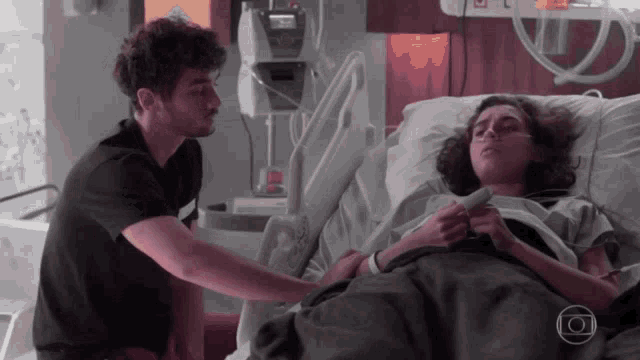 a man is standing next to a woman in a hospital bed