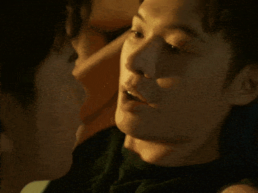 a man laying on another man 's back with a hand on his neck
