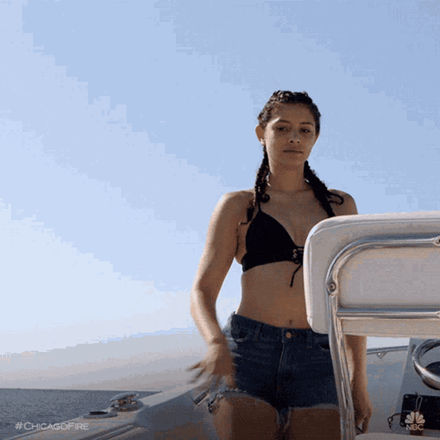a woman in a bikini and shorts is on a boat with the hashtag #chicagofire