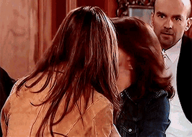 a man and a woman are kissing in a room