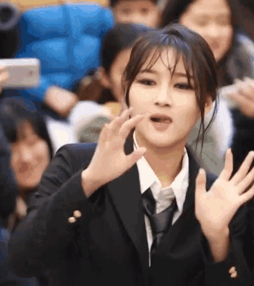 a woman in a suit and tie is making a face