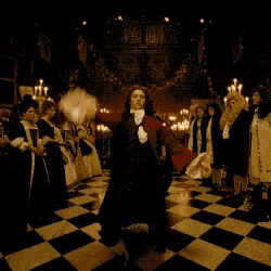 a man in a red cape is dancing in front of a crowd of people