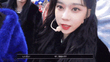 a girl with a microphone around her neck is wearing a blue jacket