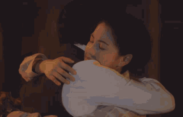 a man in a suit is hugging a woman with his eyes closed