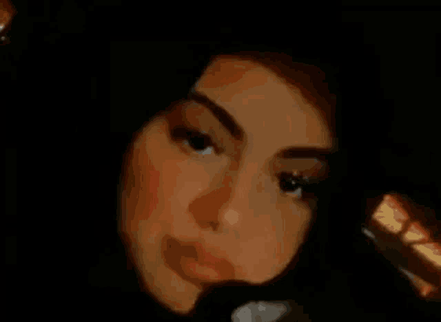 a close up of a woman 's face in the dark with a blurred background .