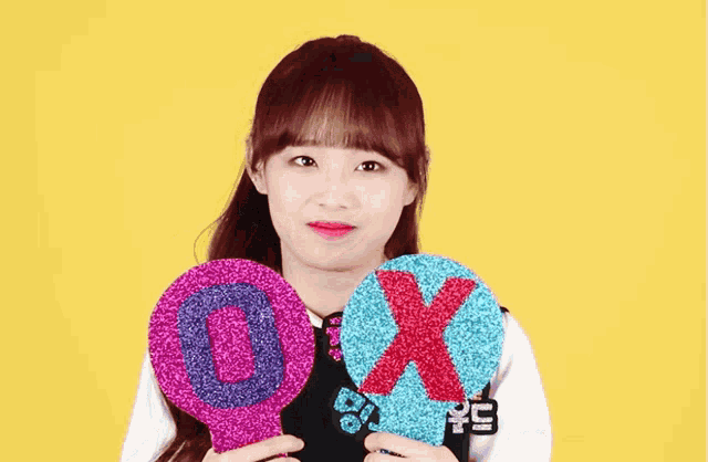 a girl with red hair is holding a sign that says x