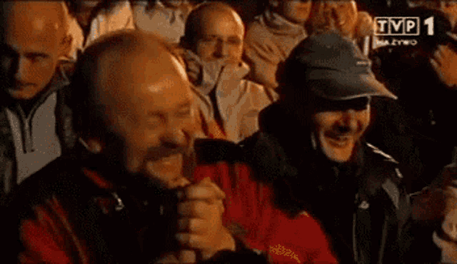 a group of men are watching a tv show called tvp