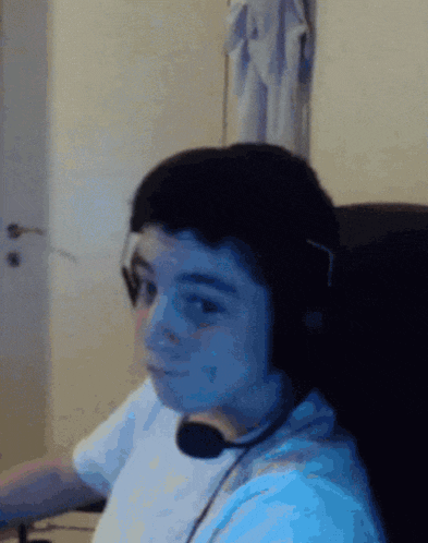 a young boy wearing headphones and a microphone is sitting in a chair