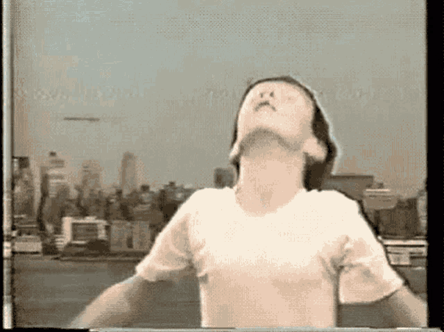 a man in a white shirt is standing in front of a city skyline .