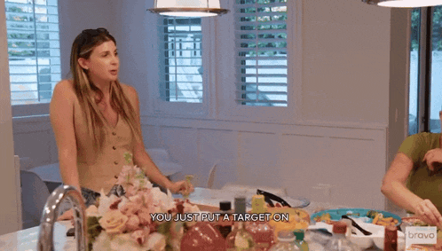 a woman is standing in front of a table with a bravo logo on it