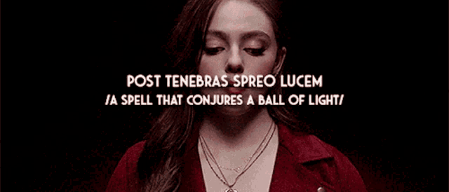 a woman is wearing a red jacket and a necklace with the words post tenebras spreo lucem written above her