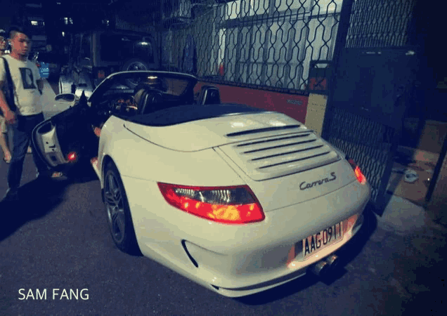 a white carrera s is parked on the street