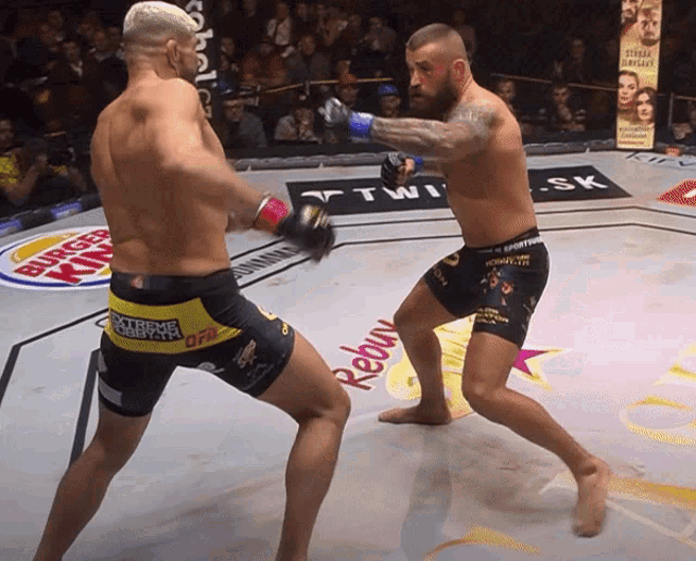 two fighters are fighting in a ring with a burger king sign in the background