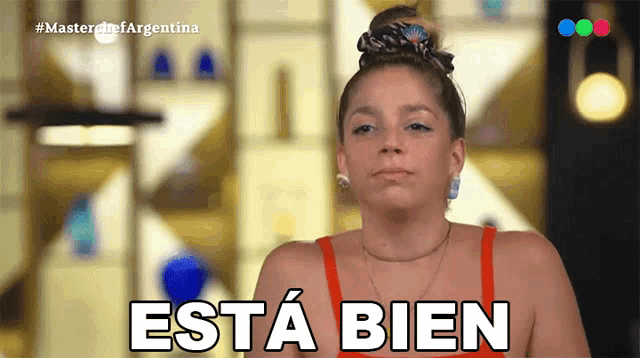 a woman in a red top says " esta bien " in spanish