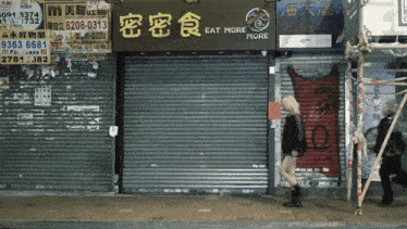 a woman walks past a store that says eat more
