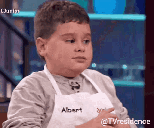 a young boy wearing an apron with albert written on it