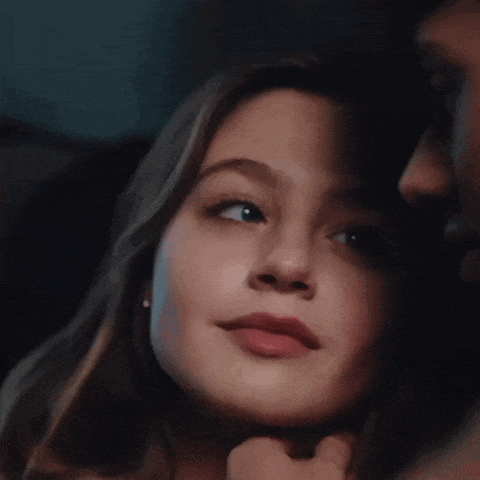 a close up of a woman 's face with a man 's hand on her chin