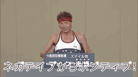 a man is standing at a podium wearing a red headband and giving a speech in a foreign language .