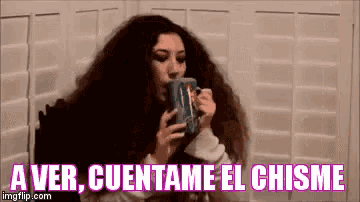 a woman with long hair is drinking from a mug with the words a ver cuentame el chisme above her