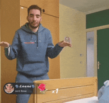 a man in a blue hoodie is standing next to a bed with a rose and a message from loane sent rose
