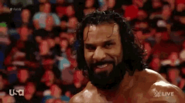 a man with a beard is standing in front of a crowd of people .