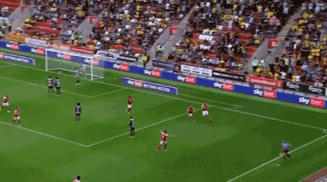 a group of soccer players are standing on a field and one of them is covering his face with his hands .