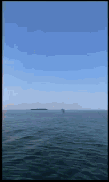 a large body of water with a blue sky
