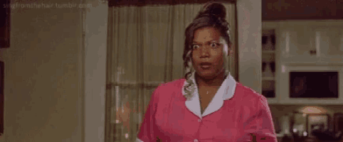 a woman in a pink maid 's uniform is standing in a room .