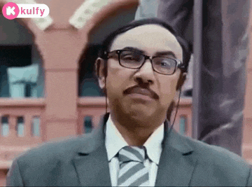 a man in a suit and tie with glasses and a mustache is making a funny face .