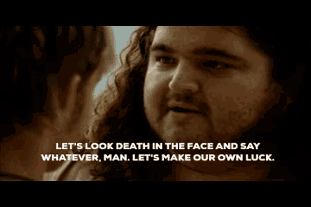 a man with long hair and a beard talks to another man