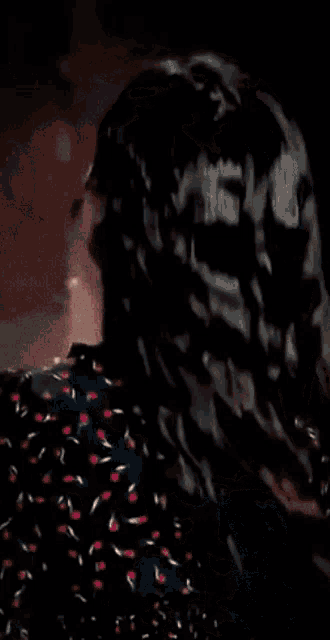 a close up of a woman 's face wearing a floral dress