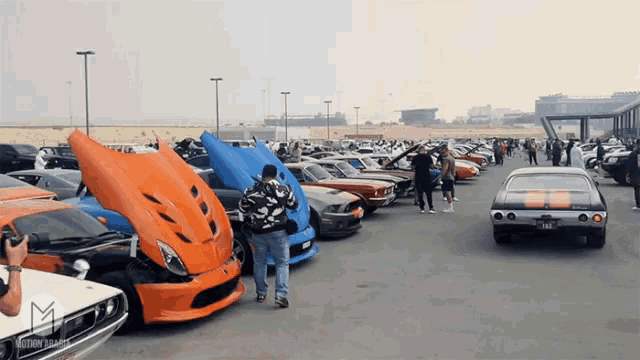 a row of cars are parked in a parking lot with the letters m on the bottom
