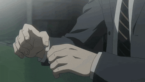 a man in a suit and tie has his hands on his sleeve
