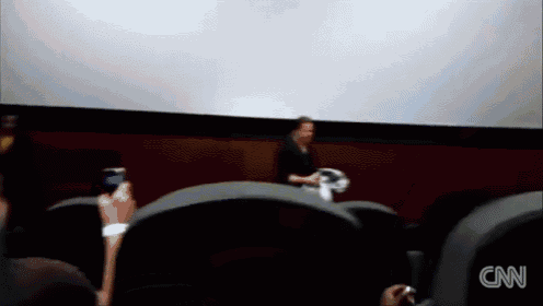 a blurred image of people watching a movie with the cnn logo on the bottom left