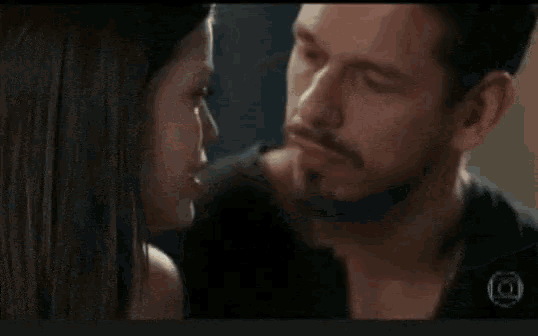 a man and a woman are kissing each other in a room .