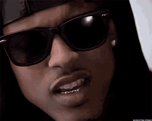 a close up of a man wearing sunglasses and a hoodie