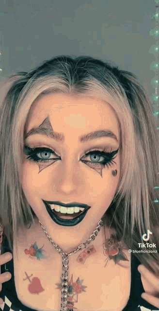 a woman with a tattoo on her neck is wearing a harley quinn makeup look