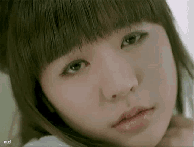 a close up of a woman 's face with the words a.d on the bottom