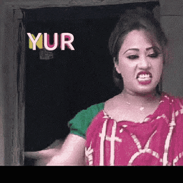 a woman in a red and green dress is making a funny face in front of a sign that says ' yur '