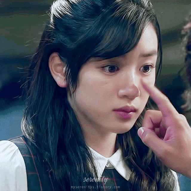 a woman 's face is being touched by a man 's finger with serenity written on the bottom right