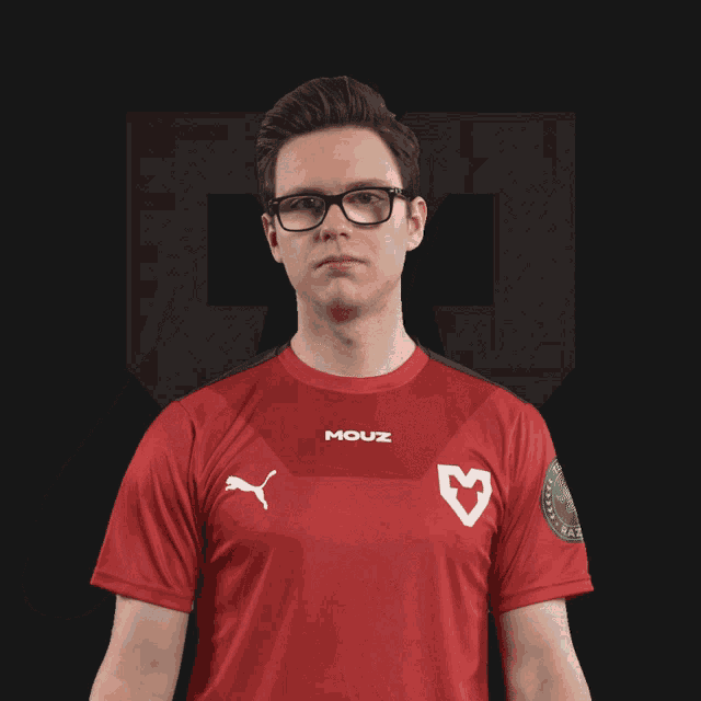 a man wearing a red shirt that says mouz on the front